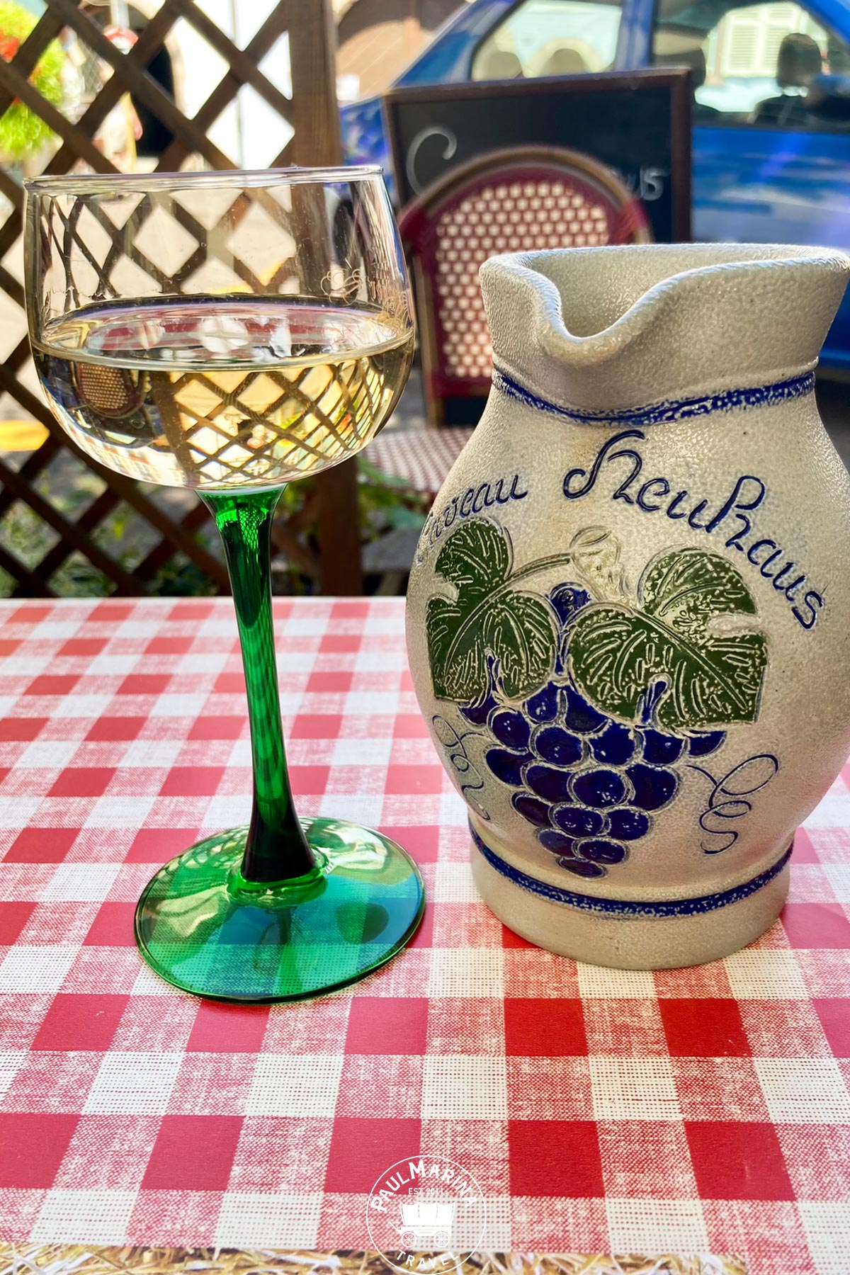 Traditional wine glass with green stem and pottery jug in Alsace