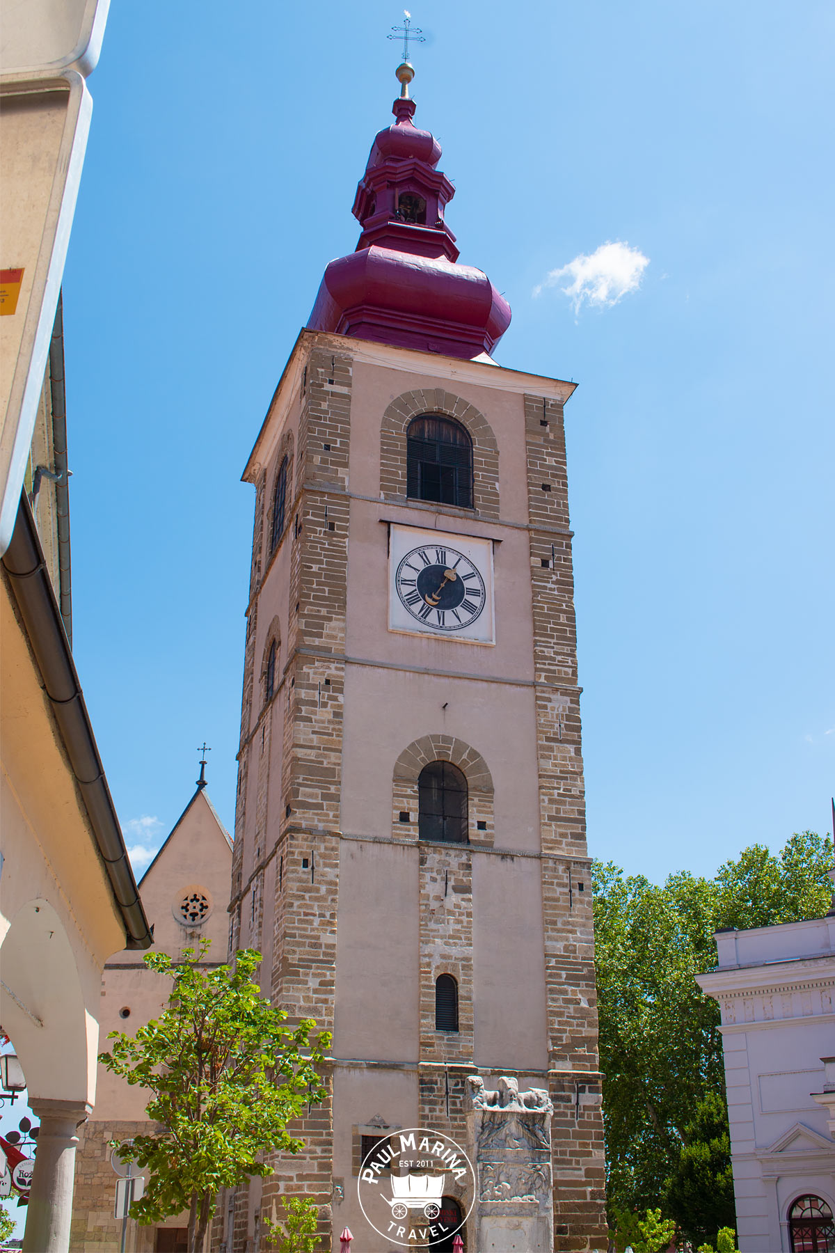 Clock tower of Ptuj with orpheus monument at the bottom