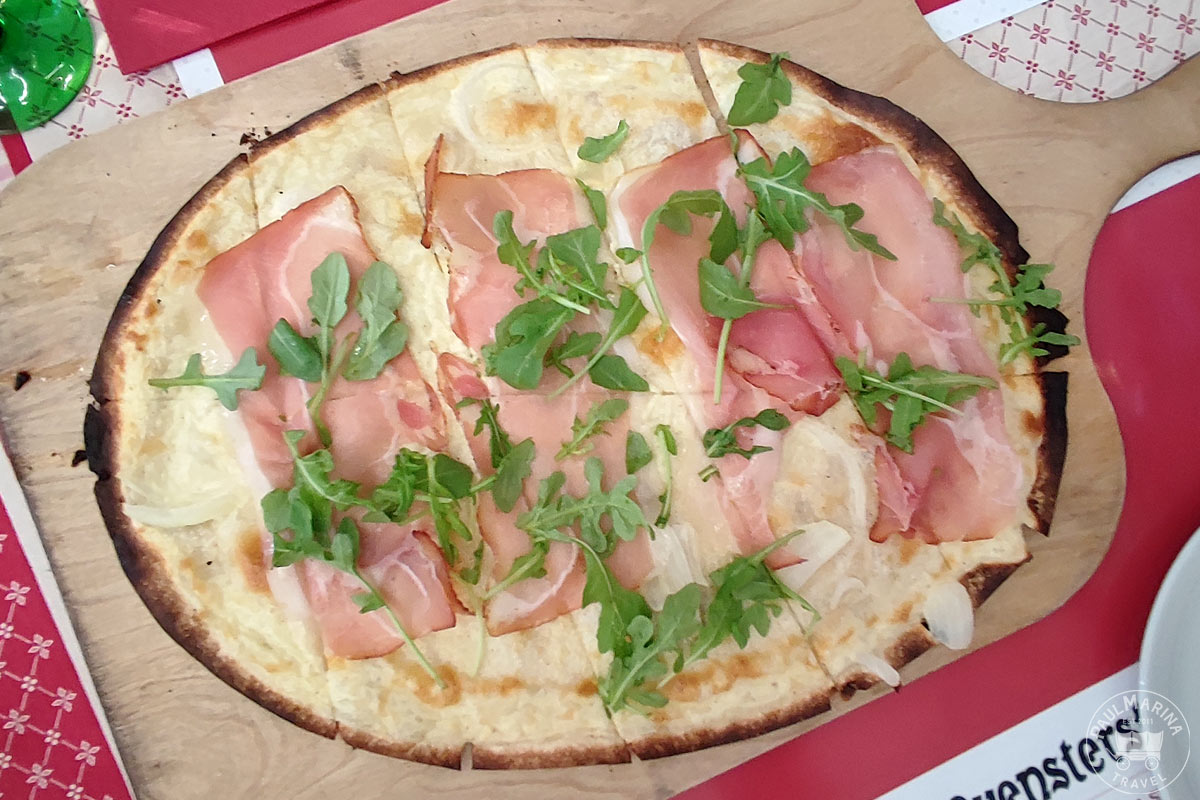 Flammkueche aka Tarte Flambée with a ham, onion arugula topping at the Muensterstuewel Restaurant in Strasbourg Alsace